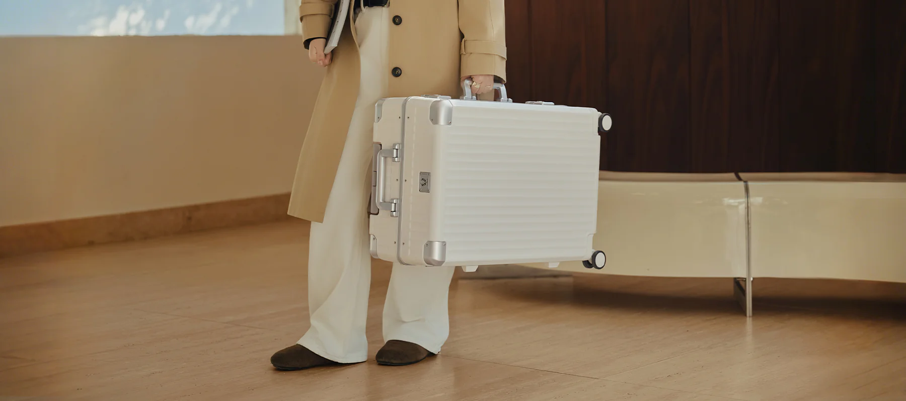 White aluminum luggage carried in a refined interior